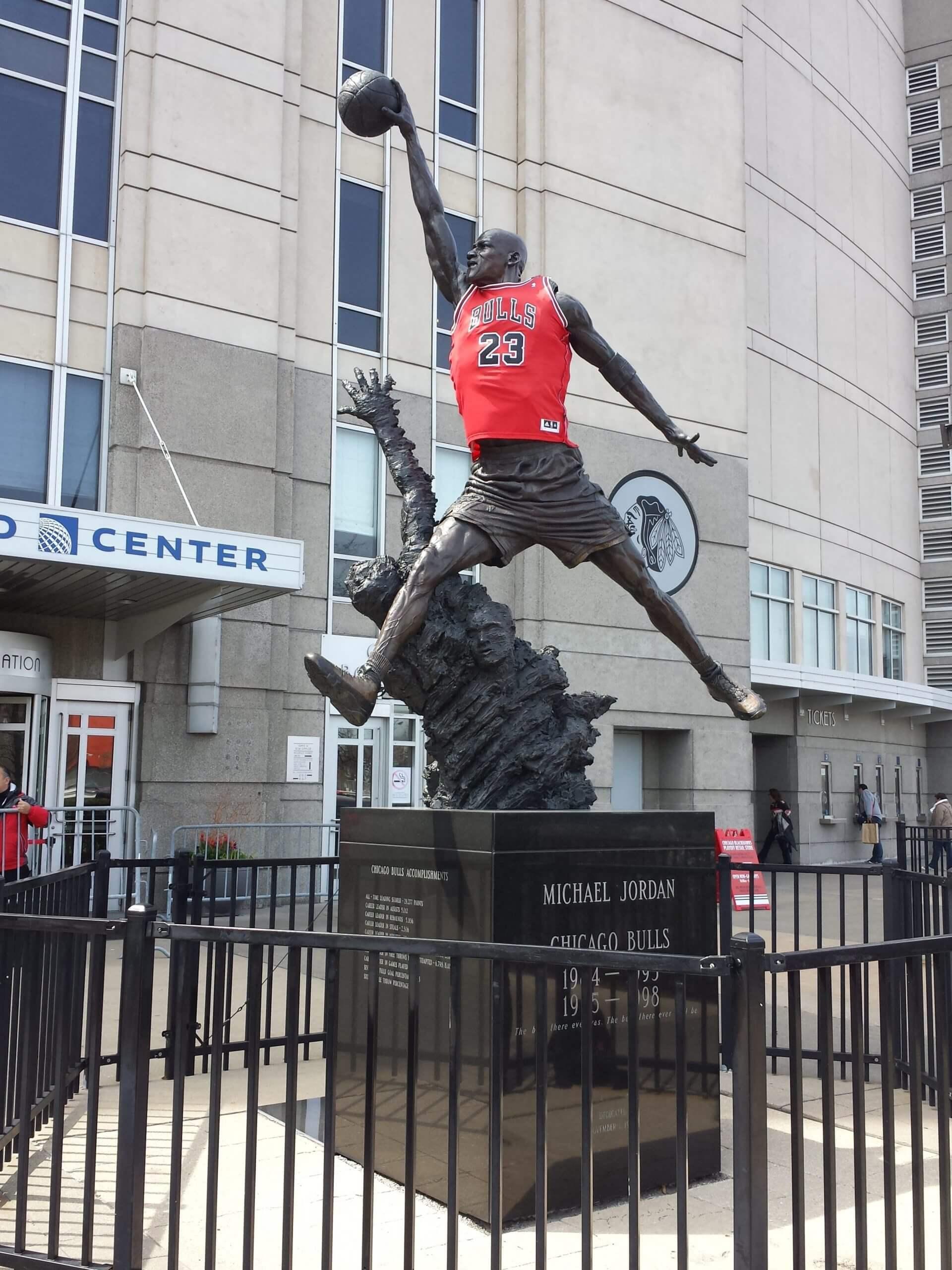 Statue of Michael Jordan in a Bulls jersey outside of a basketball stadium